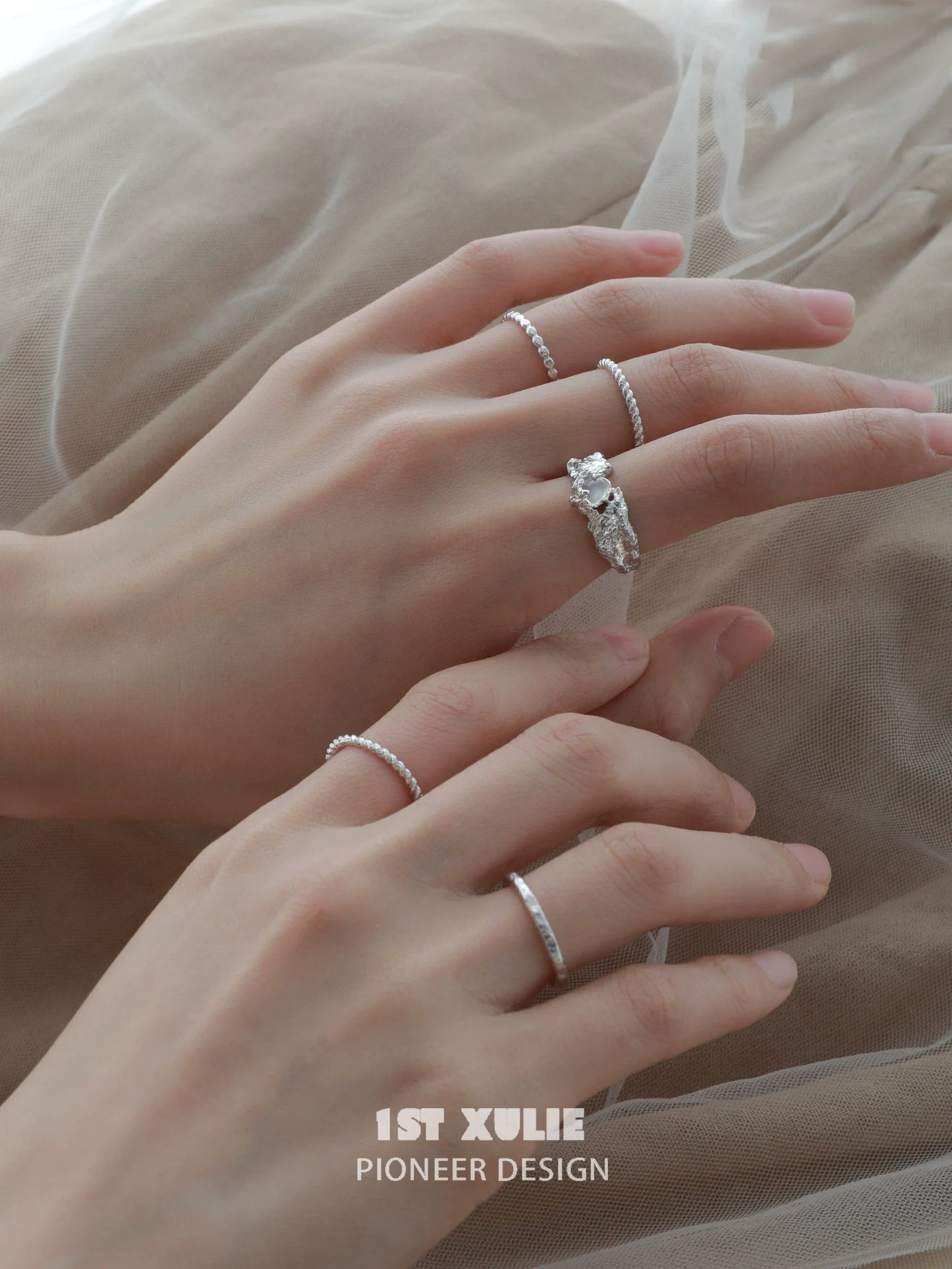 Elegant white agate ring showcased on a model's hand among other stacking rings
