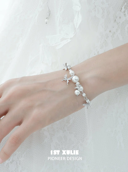 White butterfly pearl bracelet with elegant silver accents on a model's wrist