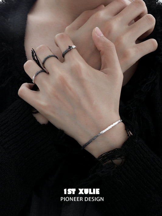 Y2K black and white couple bracelet displayed on hands wearing stylish rings and textured accessories