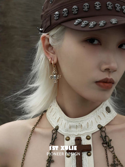 Y2K cross earrings with intricate designs worn by a model accessorized in stylish streetwear
