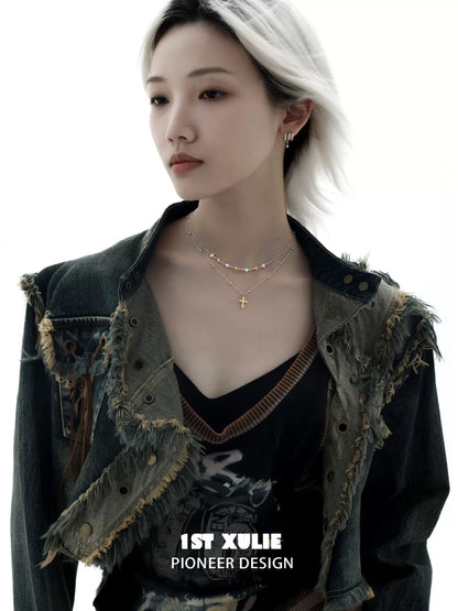 Y2K cross necklace layered with delicate chains, styled with an edgy denim jacket