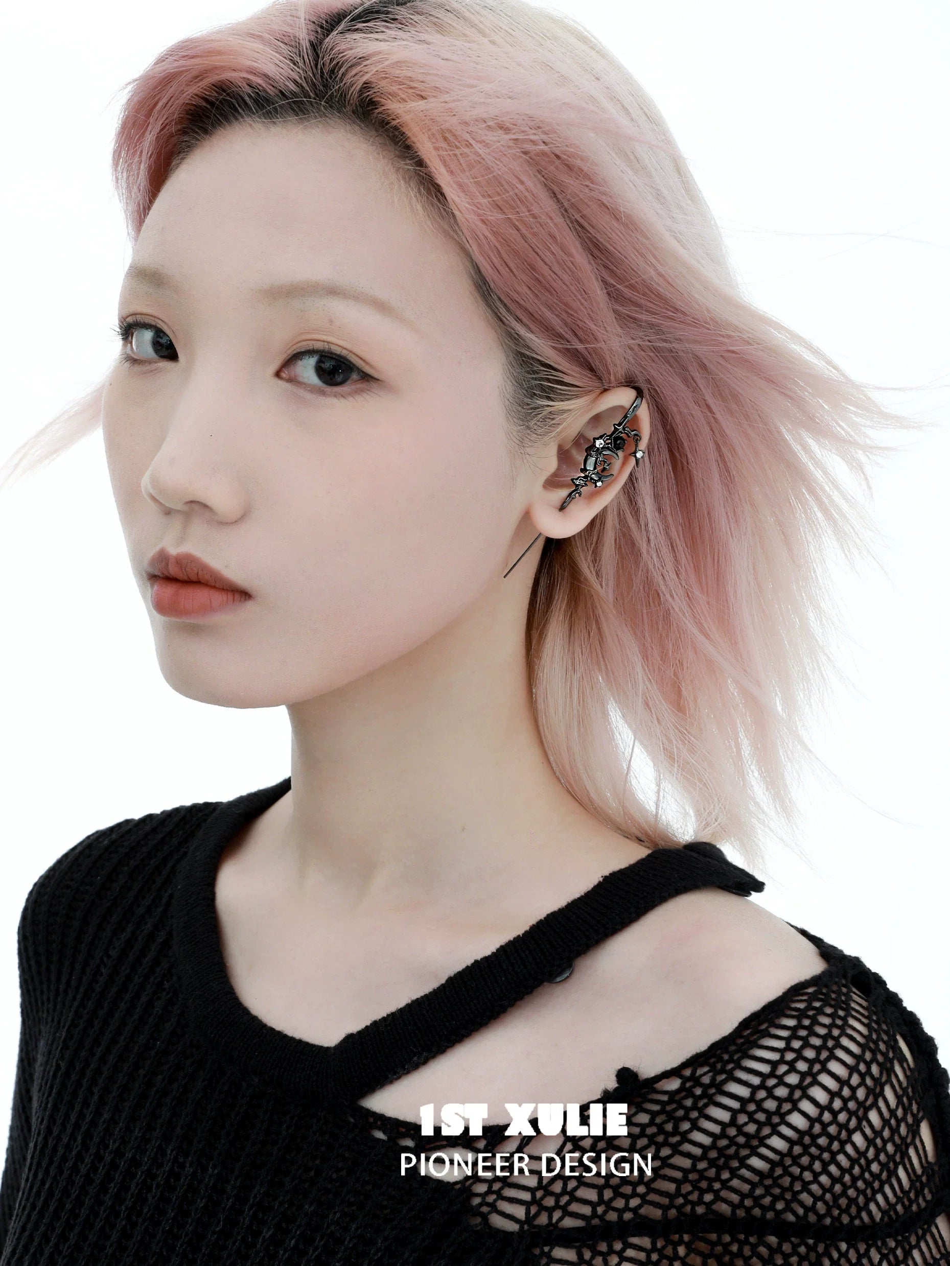 Y2K dark moon ear piercing showcased on a model with pink hair and a black sweater