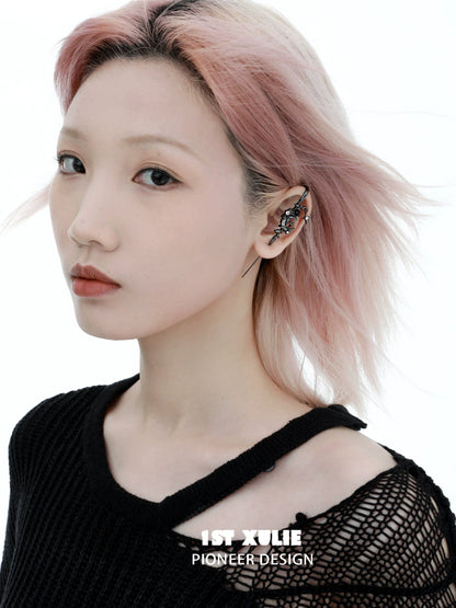 Y2K dark moon ear piercing showcased on a model with pink hair and a black sweater