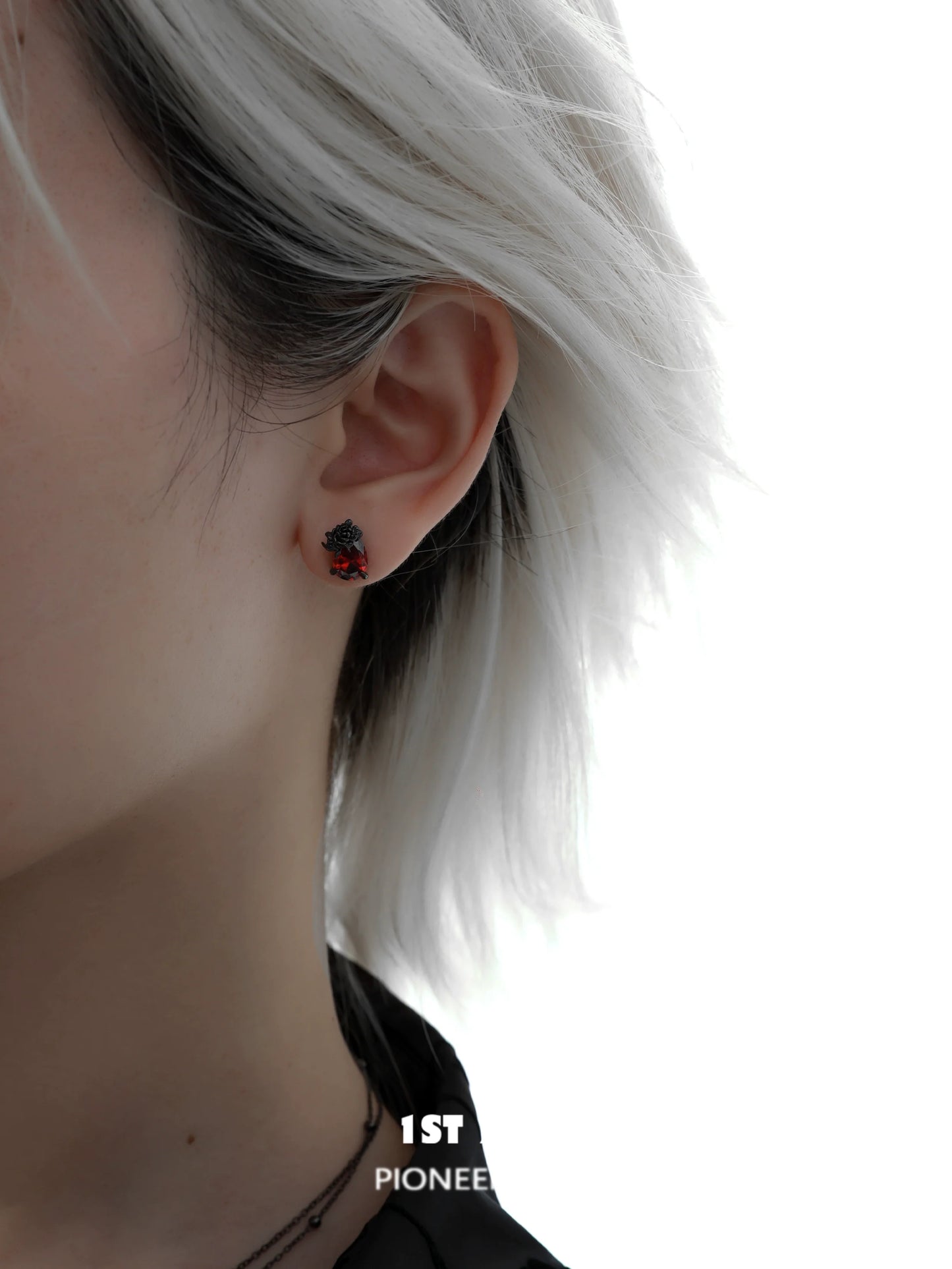 Close-up of Y2K dark rose earrings worn by a model with short light-colored hair