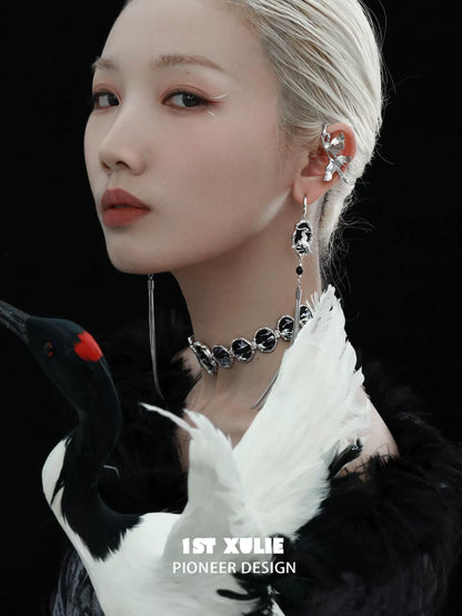 Y2K dark tassel earrings showcased on a model with a striking hairstyle and bold makeup