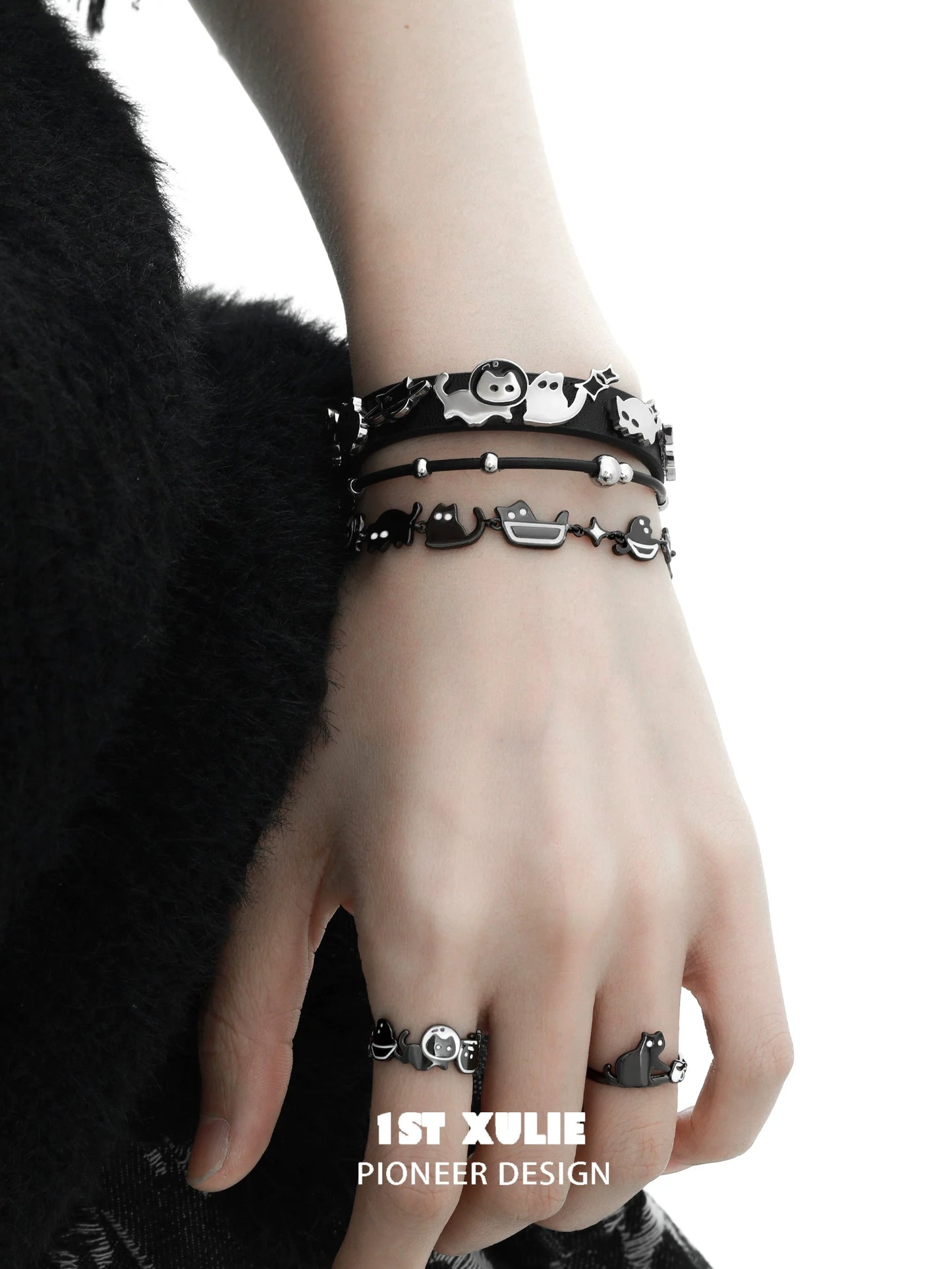 Y2K kitty leather bracelet stacked on a hand with multiple playful cat-themed designs