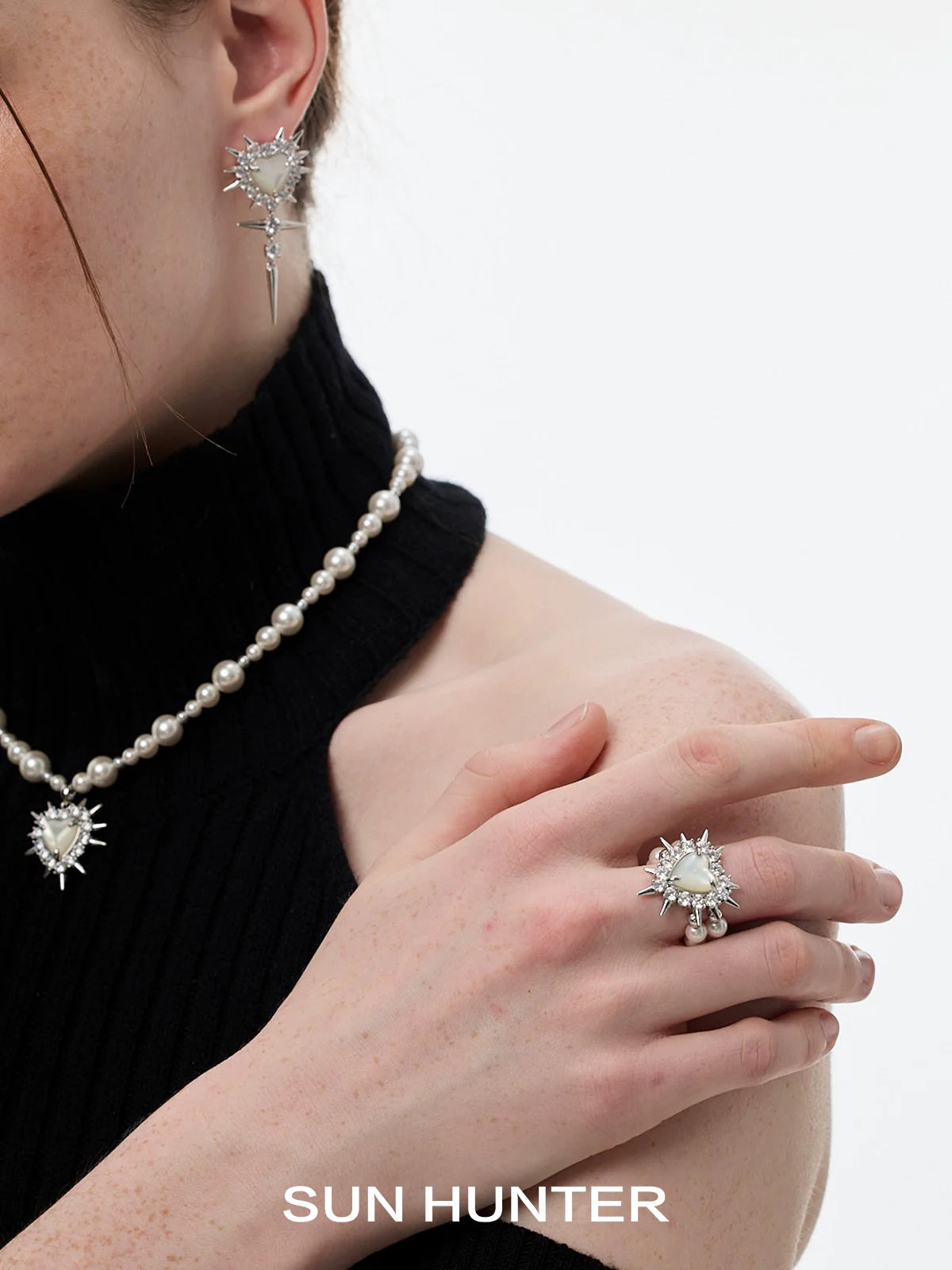 Y2K pearl rivet ring worn with matching jewelry showcasing a stylish look from SUN HUNTER