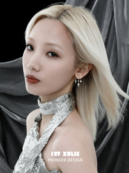 Model wearing Y2K snake earrings with a modern silver outfit against a dark background