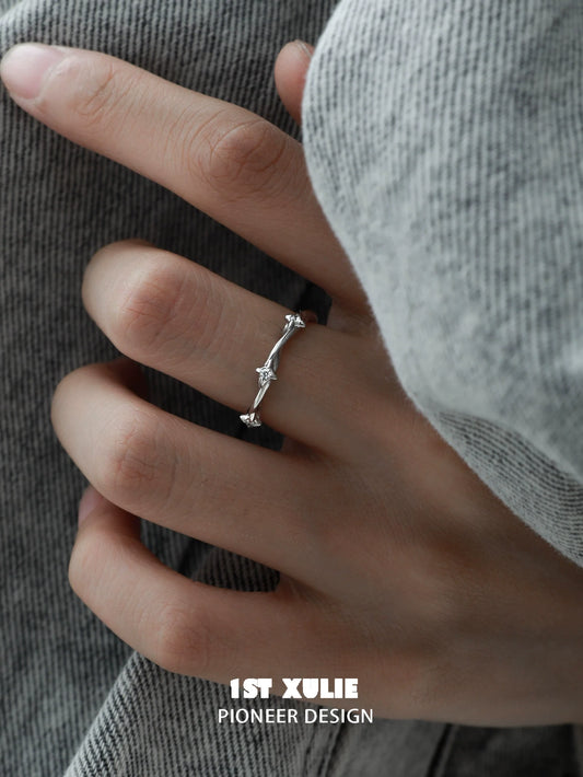 Y2K twisted spiral silver ring worn on a hand with a cozy sweater background